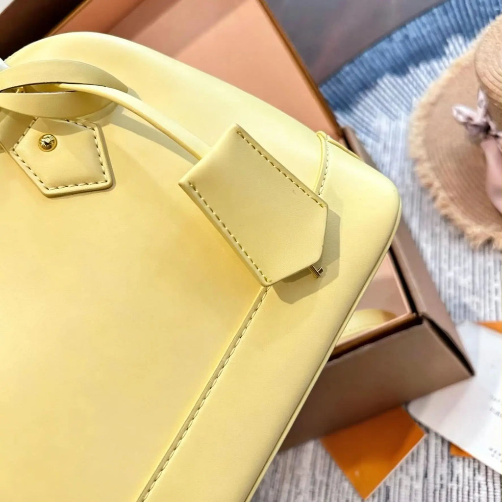 Yellow smooth calf leather handbag, with gold-tone lock hardware, top handle, detachable matching crossbody strap, small shell shoulder bag.